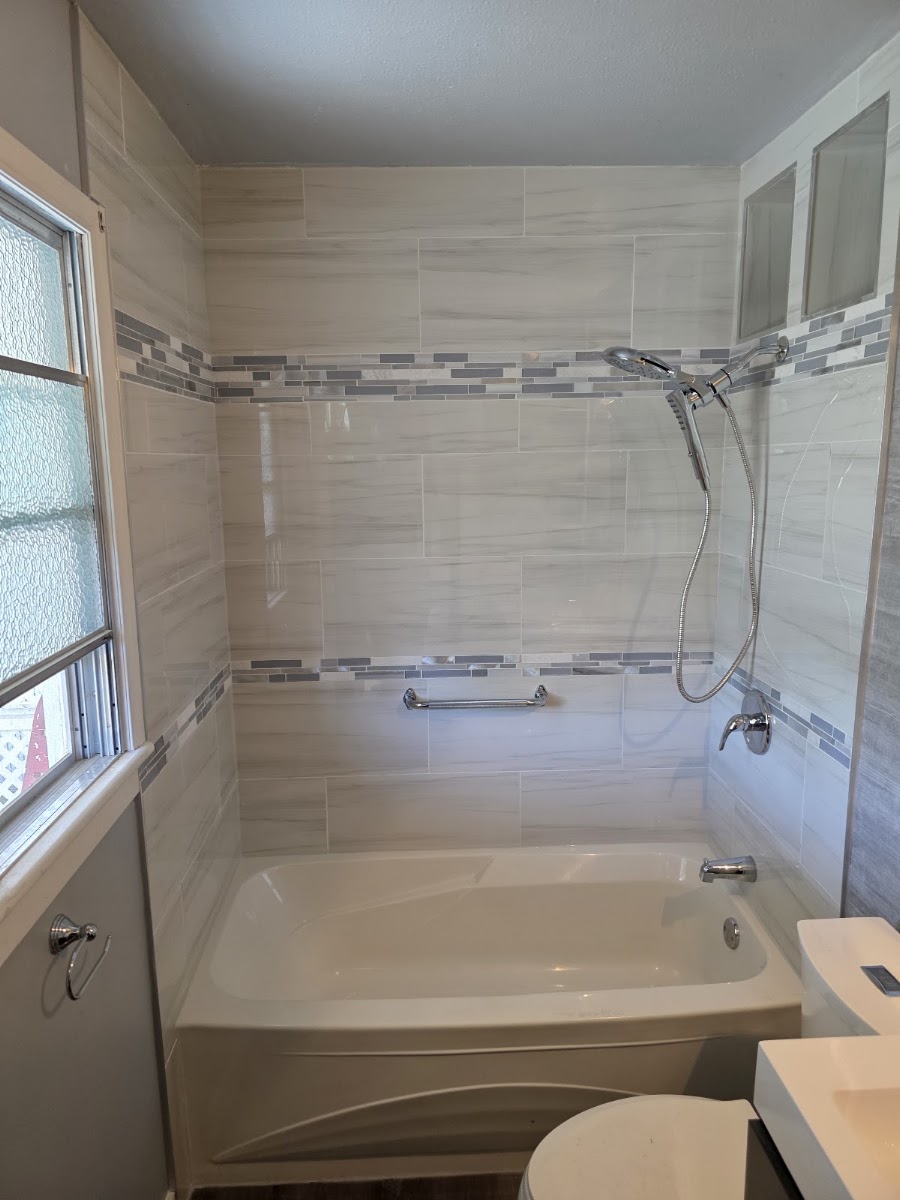 Walk-in shower installation with tile surround and glass enclosure
