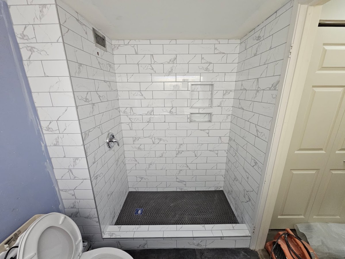 Completed master bathroom with dual sinks and custom tile shower walls